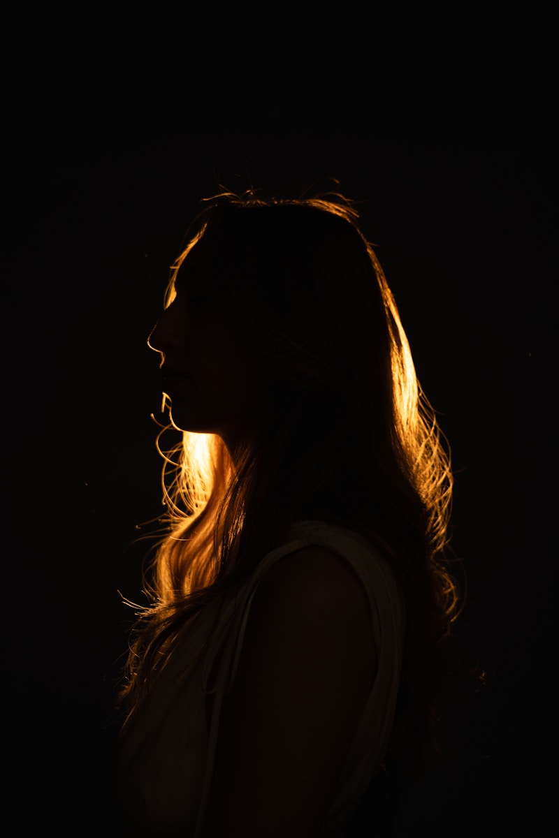 Photo by Jay Soundo A woman is silhouetted against a golden glow.